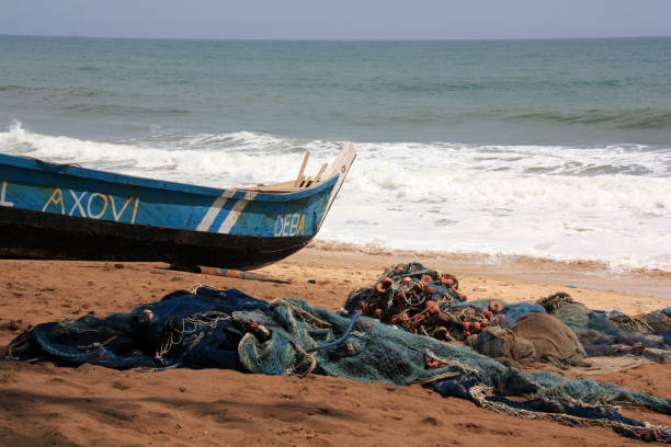 łódź rybacka na plaży w pobliżu cape coast, ghana - rowboat fishing africa fishing industry zdjęcia i obrazy z banku zdjęć