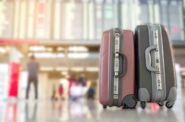 istock Selected focus on two baggage at the airport terminal with flight schedule board as a blurred background. Travel concept. 1011987126