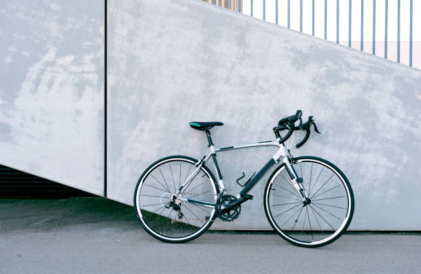 콘크리트 벽 옆에 서 있는 자전거 경주 - 경주용 자전거 뉴스 사진 이미지
