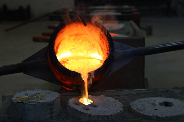 Foundry - molten metal poured from ladle into mould stock photo