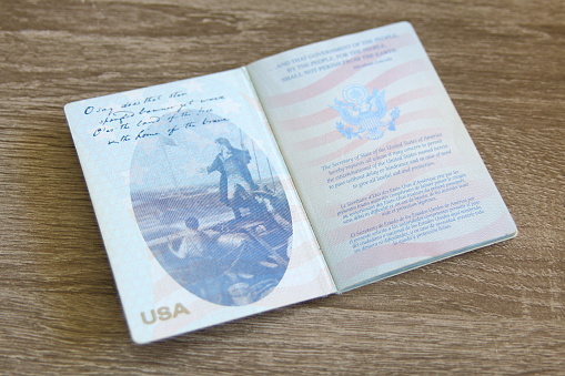 US passport over a light grey wooden background