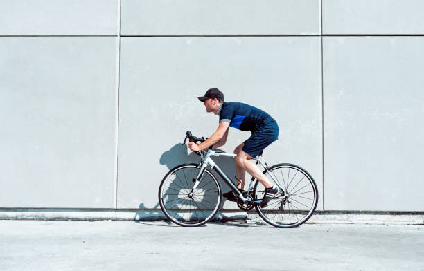 istock Sun shines while man rides bicycle next to concrete wall 1012005038