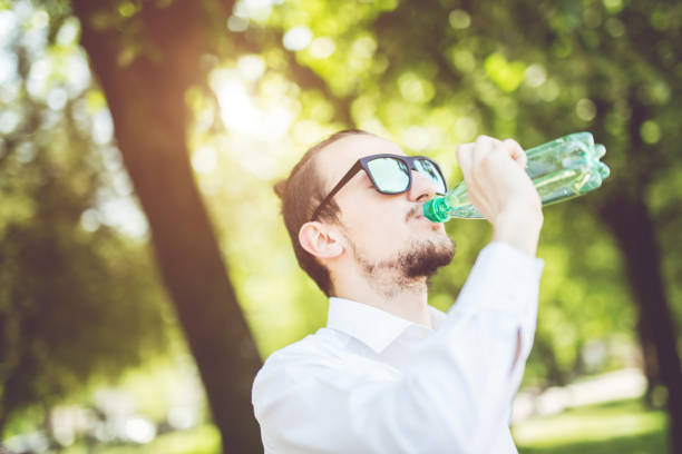 istock Portrait of young man drinks water outside. 1012013888