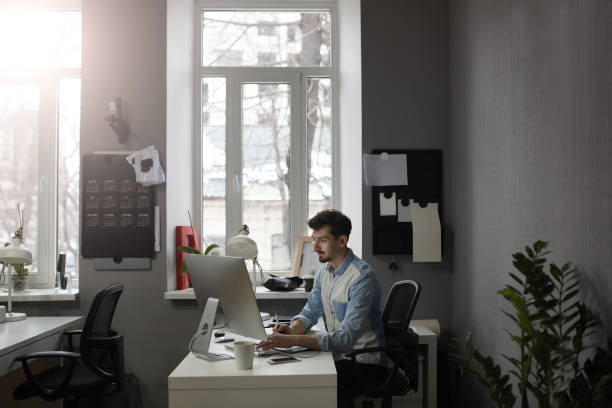 istock Young intelligent bearded man working at modern loft studio-offi 1012020200