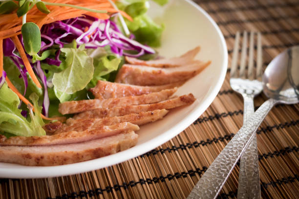 Thai food, Steamed pork with spicy lemon sauce salad served with fresh green vegetables on white background