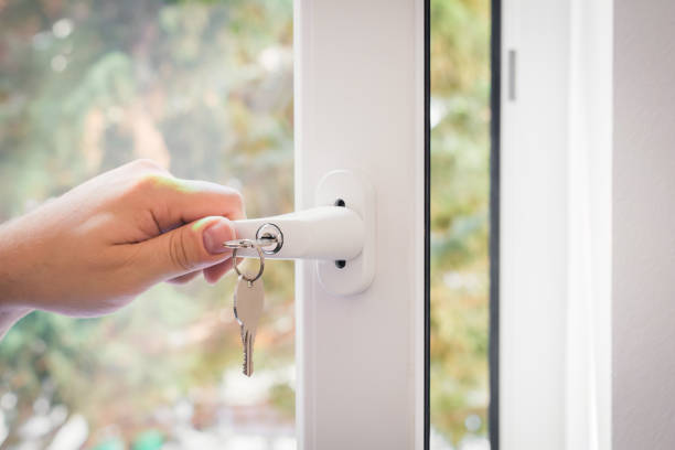 Window With A Lockable Handle And Keys Closed By A Male Hand, Childproof Window Concept stock photo