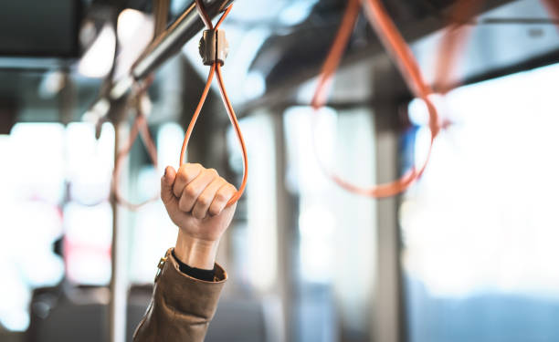 istock Hand holding the handle in tram, train, bus or subway. Passenger standing in public transportation. Person commuting. 1012048870