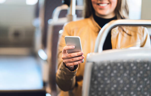 istock Smiling woman using smartphone in train, subway, bus or tram. Lady texting in public transportation or using the free wifi connection. 1012048904
