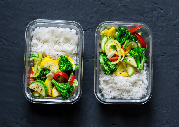 ベジタリアン弁当 - 野菜の煮込みと暗い背景、上面に米。健康食品のコンセプト - lunch box packed lunch school lunch lunch ストックフォトと画像