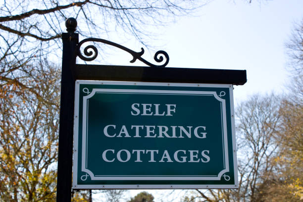 istock Sign board, signpost with words SELF CATERING COTTAGES 1012051594