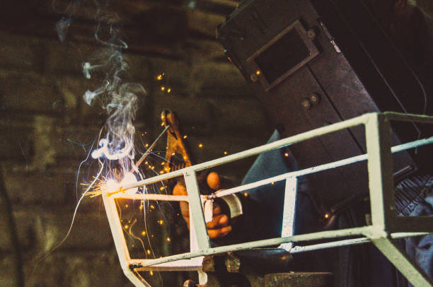 istock Welder welding metal in workshop with sparks 1012055254