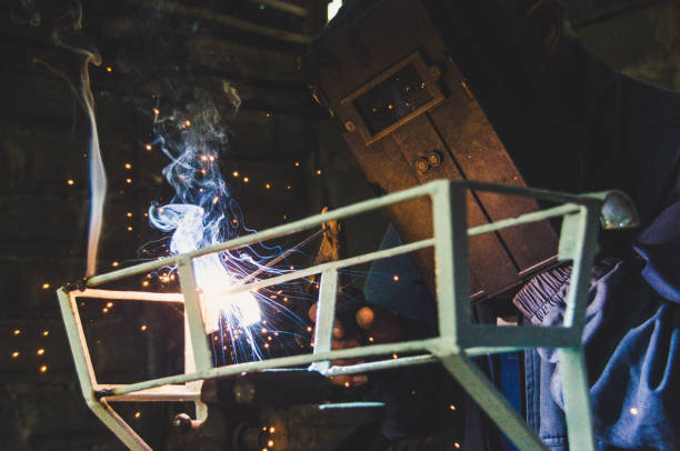 istock Welder welding metal in workshop with sparks 1012055654