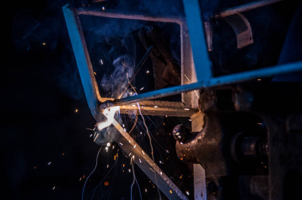 istock Welder welding metal in workshop with sparks 1012060566