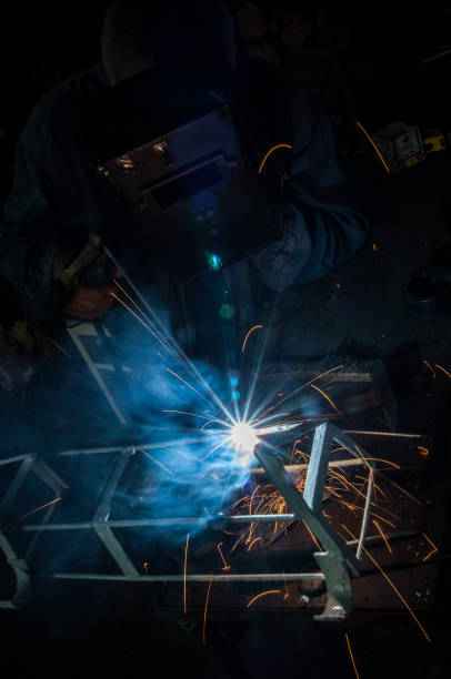 istock Welder welding metal in workshop with sparks 1012064562