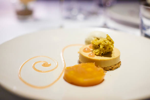 A dish of  Salted Caramel & Pistacchio cheesecake  served at a fine restaurant. This is shot at table during a dinner with the table service visible