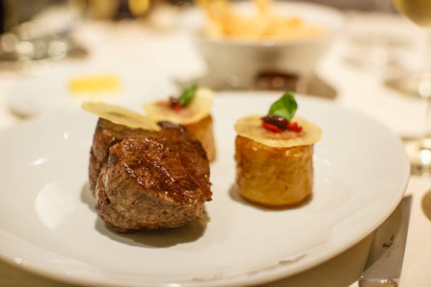 istock Grilled Beef Tournedos and Roast potatoes at a fine restaurant dinner setting 1012084106