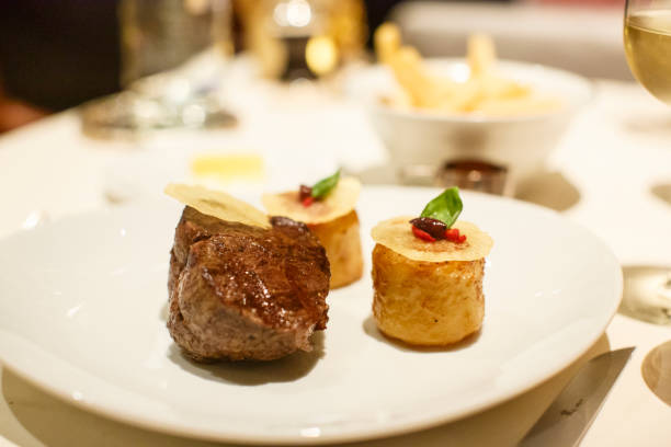 istock Grilled Beef Tournedos and Roast potatoes at a fine restaurant dinner setting 1012084136