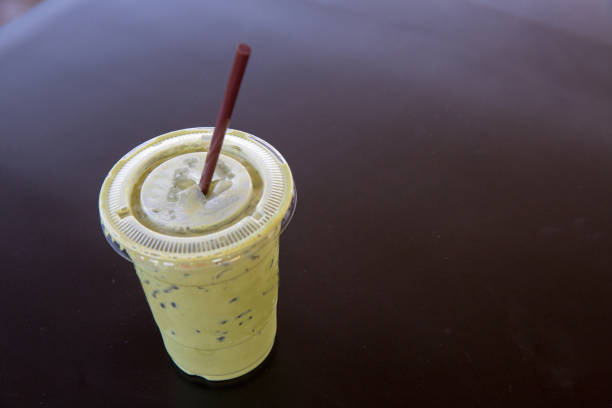 Close up green tea frappe and a straw on light bokeh background, soft and blur style for background, wallpaper and copy space.