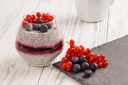Chia pudding with red and black currant on stone platter