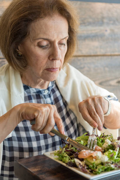 istock Senior Woman having lunch 1012132944