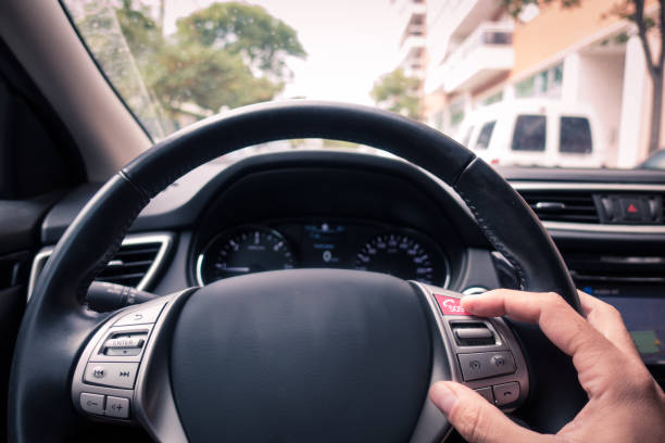 Man's hand touching an ecall button in the wheels's car stock photo