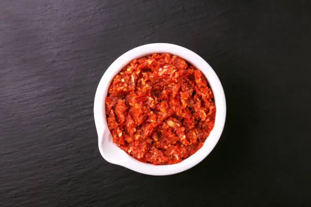 Photo of Traditional Maghrebi hot chili pepper sauce paste harissa. adjika