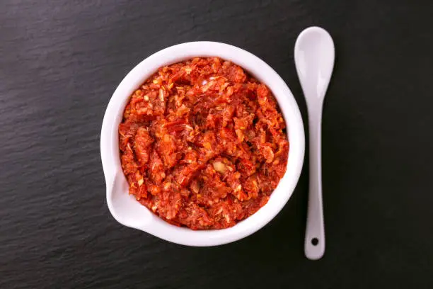 Photo of Traditional Maghrebi hot chili pepper sauce paste harissa. adjika