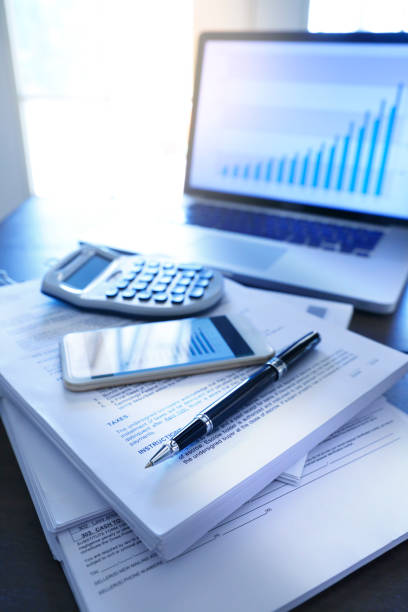 istock Ballpoint Pen A Mobile Phone And A Calculator Resting On Top Of Stack Of Documents 1012160518