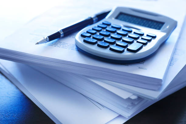 istock Ballpoint Pen And A Calculator Resting On Top Of Stack Of Documents 1012160868