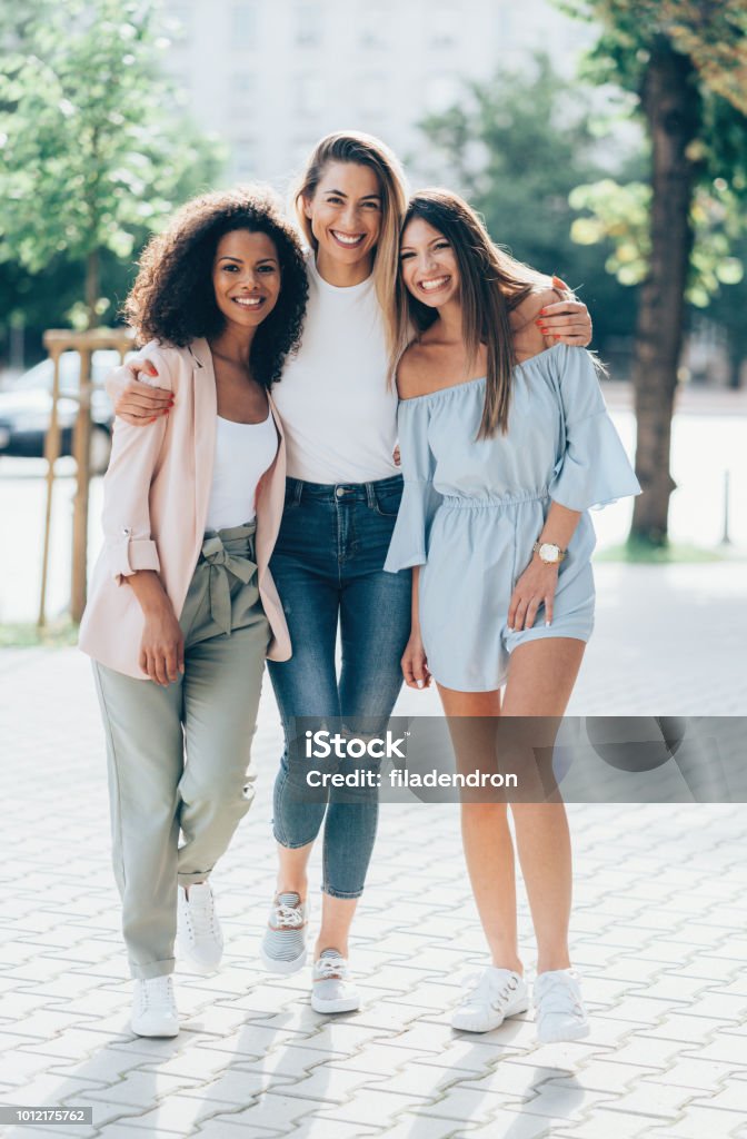 Three Girlfriends looking happy together Three Girlfriends looking happy together outdoors in sunny summer day Women Stock Photo