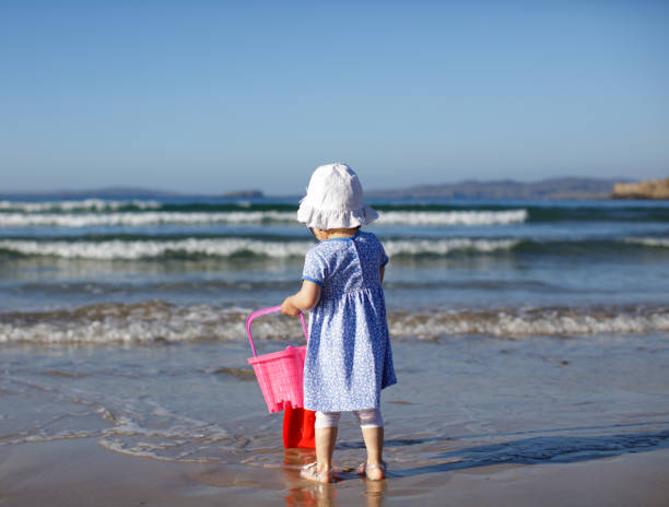 istock baby girl playing at summer beach 1012185818