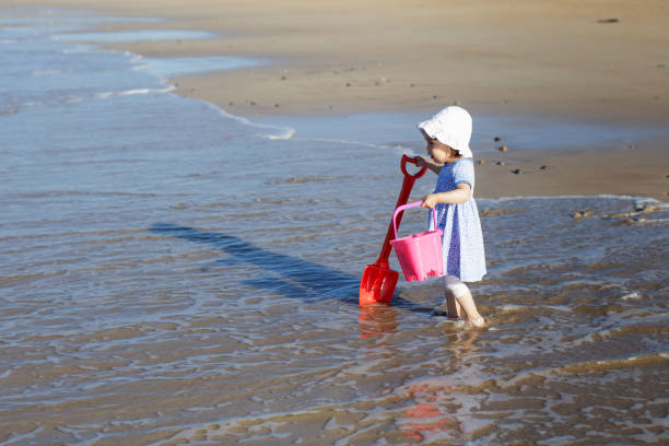 istock baby girl playing at summer beach 1012185864