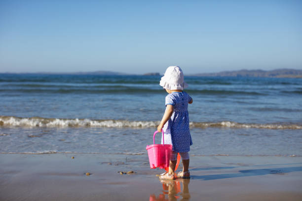 istock baby girl playing at summer beach 1012185886