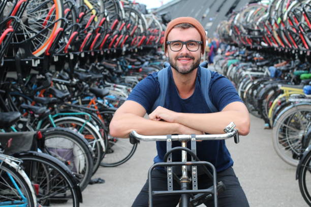 Man giving smiling at bicycle parking lot.