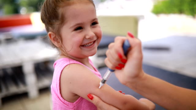 Smiling child taking an insulin injection