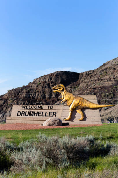 Drumheller Sign Dinosaur July 12, 2018 - Drumheller, Alberta, Canada: Welcome to Drumheller sign with dinosaur at the entrance to town in Drumheller, Alberta, Canada. drumheller valley stock pictures, royalty-free photos & images