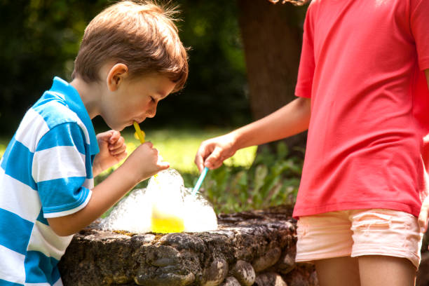 istock brother and sister blowing soap bubbles 1012200034