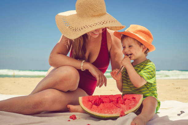istock Happy family enjoys watermelon on beach 1012200388