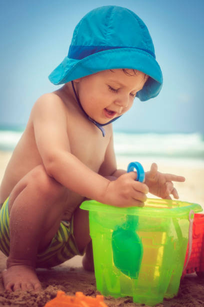 istock Happy little boy building sandcastle on the beach 1012200404