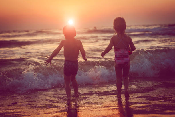 istock Children enjoying sunset in the sea 1012200448