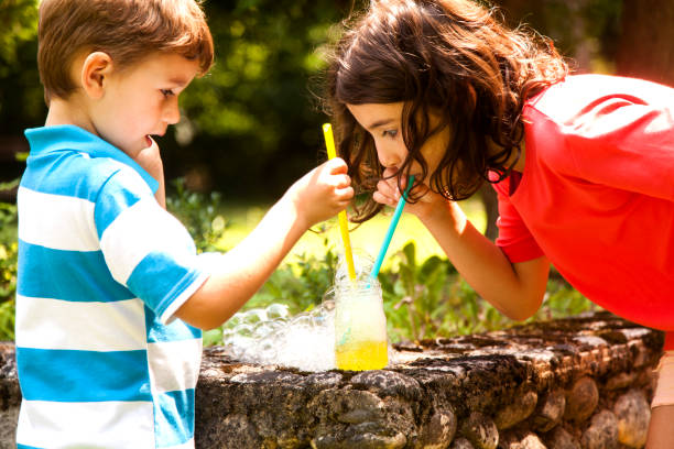 istock brother and sister blowing soap bubbles 1012202572