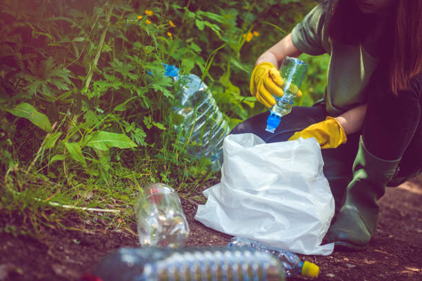 Volunteer collects plastic bottles outdoors