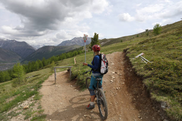 istock Mountain biker checks smart phone for direction, trail fork 1012202924