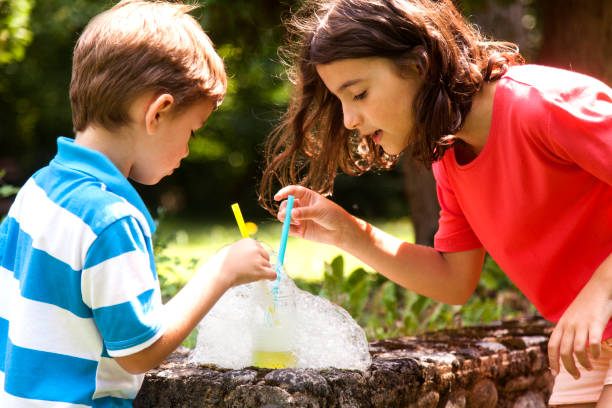 istock brother and sister blowing soap bubbles 1012203088