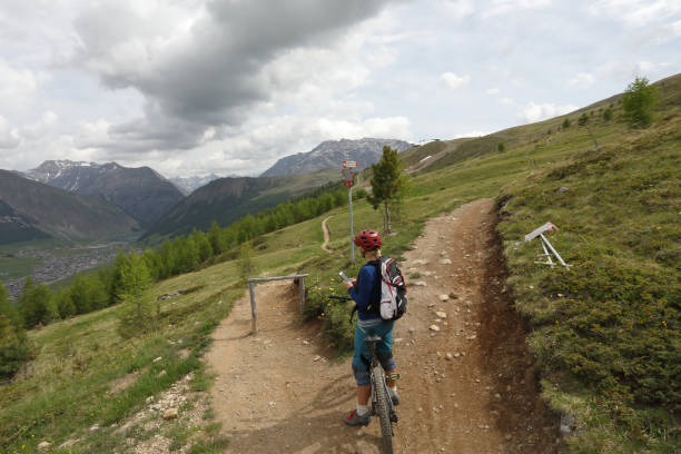 istock Mountain biker checks smart phone for direction, trail fork 1012203230