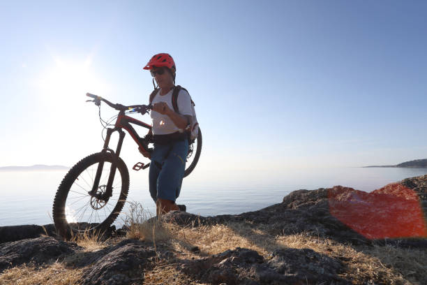 istock Mountain biker carries bike over difficult terrain 1012205752