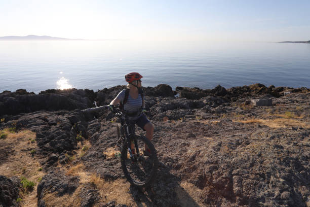 istock Mountain biker carries bike over difficult terrain 1012205840