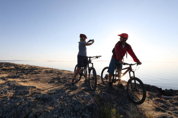 mountain biker couple take photo with smart phone - victoria british columbia imagens e fotografias de stock