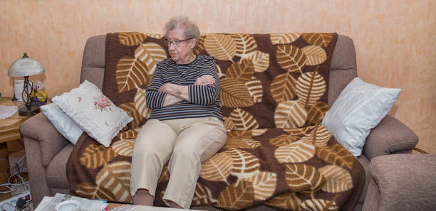 istock Over 80 year old grandmother sitting on a couch 1012220436