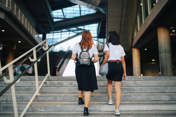 istock Two young Asian students in uniforms arriving at school or university 1012225356